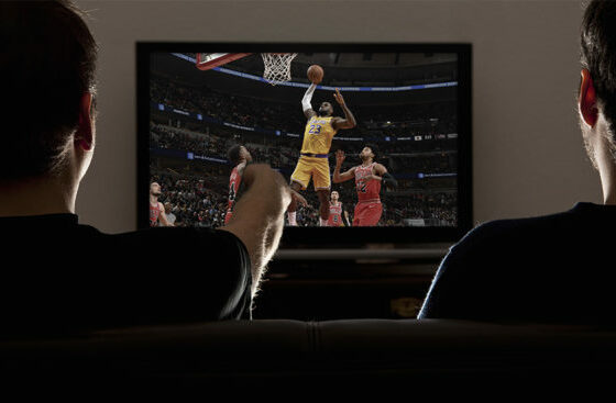 Two men watching an NBA game