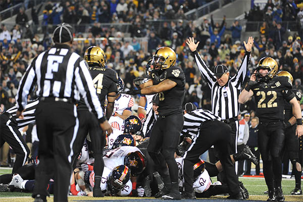 NFL Players and Officials in a Huddle