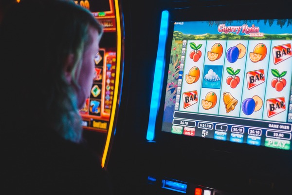 A woman playing a Cherry Rain Deluxe Slot Machine