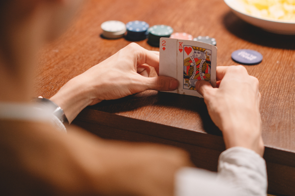 Игрок в покер с комбинацией К2 в руке